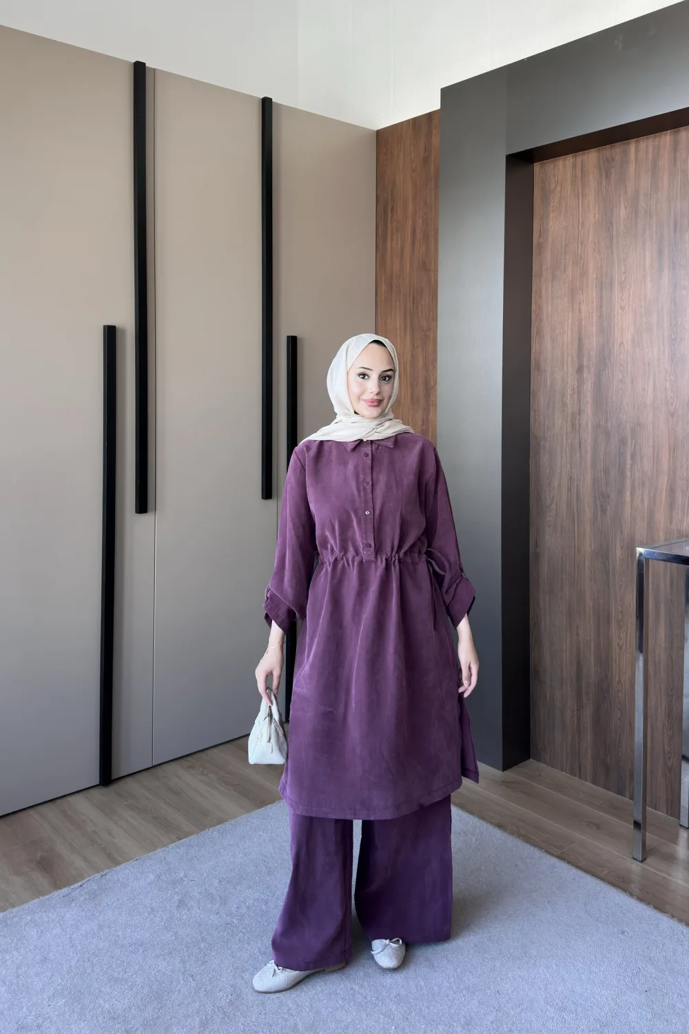 Model wearing a plum washed linen tunic with a drawstring waist over matching wide leg trousers