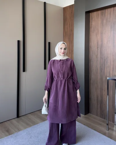 Model wearing a plum washed linen tunic with a drawstring waist over matching wide leg trousers