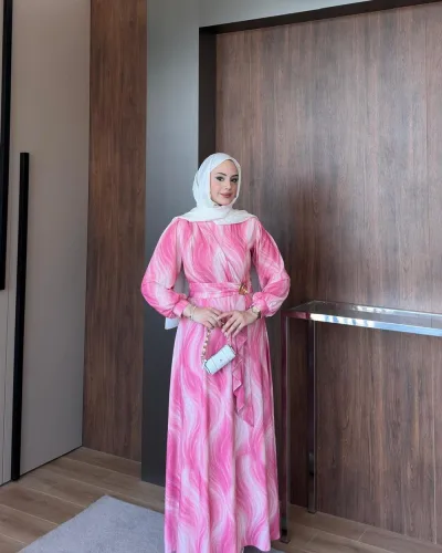 Model wearing a pink wave print chiffon maxi dress with a belted waist and long sleeves